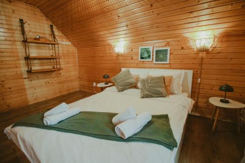 a bedroom with a large bed in a wooden cabin at Pensiunea Anda in Călăţele