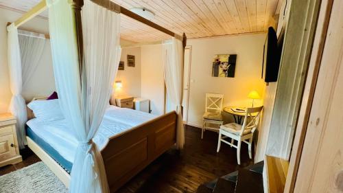 a bedroom with a canopy bed and a table at Dalen Bed & Breakfast in Dalen