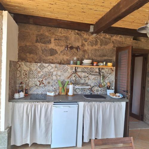 a kitchen with a table and a counter top at Dammuso Surya Il cappero monolocale in Pantelleria