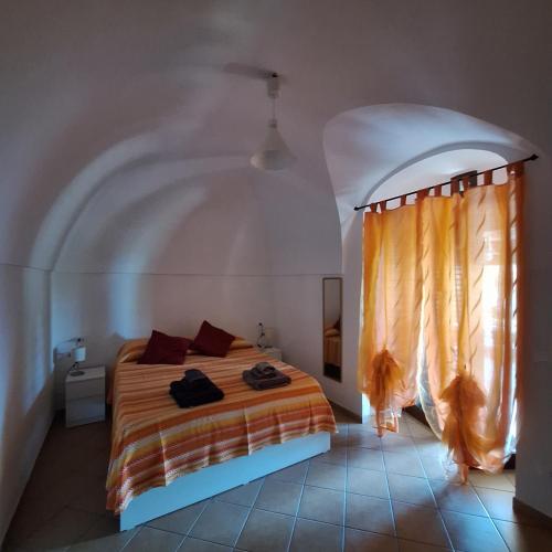 a bedroom with a bed in a room with a window at Dammuso Surya Il cappero monolocale in Pantelleria