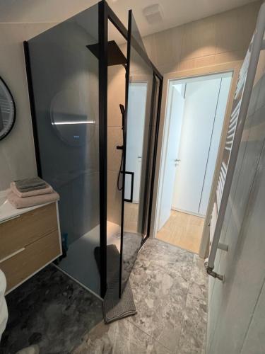 a bathroom with a glass shower and a staircase at Appartement Wonder 2 au centre de Couvet in Couvet