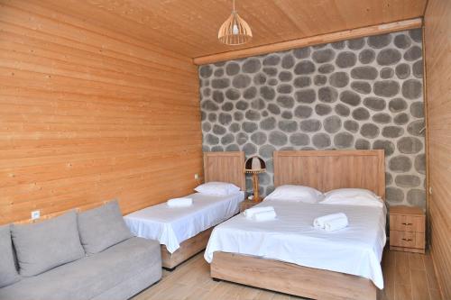 a bedroom with two beds and a couch in it at Hayi Tun Guest House in Goris