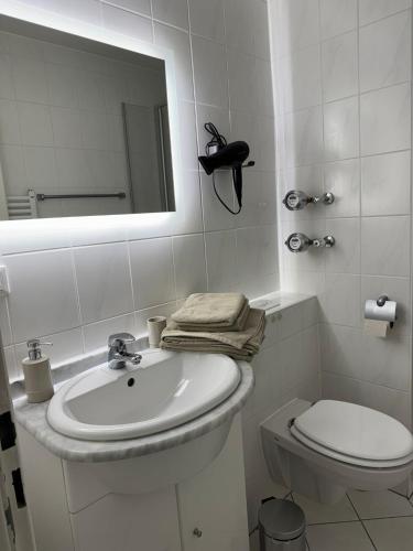 a white bathroom with a sink and a toilet at FeWo Luisa in Neureichenau