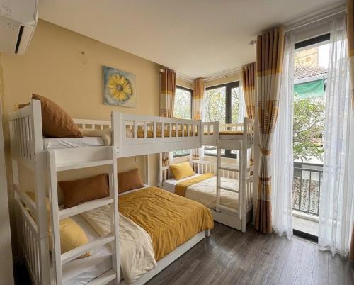 a bedroom with two bunk beds and a balcony at The New Chapter Hostel in Ho Chi Minh City