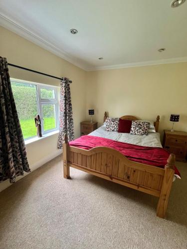 a bedroom with a wooden bed and a window at Pegs Cottage in Clonmel