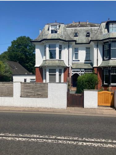 a large white house with a fence on a street at Loft Apartment, Keswick in Keswick