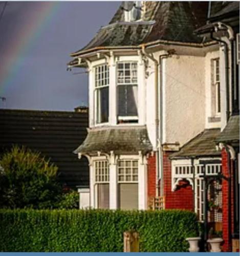 a large white house with a gambrel roof at Loft Apartment, Keswick in Keswick