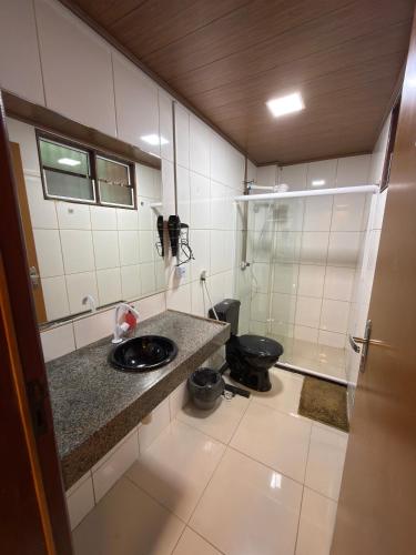 a bathroom with a toilet and a sink and a shower at Condomínio Feitosa Barros II in Maceió