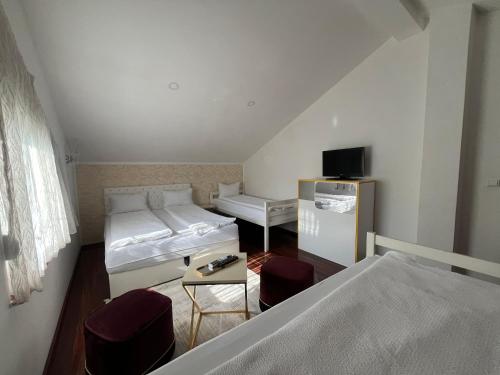 a small room with two beds and a tv at Villa Diamond Hill in Sarajevo
