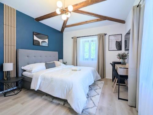 a bedroom with a white bed and a desk at Penzion Na bezu in Drahonice