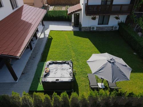 an umbrella and a boat on a yard with a lawn at Къща Александра 2 in Dobrinishte