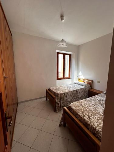 a bedroom with two beds and a window at Bastianina's home in Marciana Marina