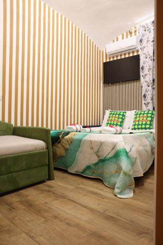 a bedroom with a bed and a green couch at Western Termini Guest House in Rome