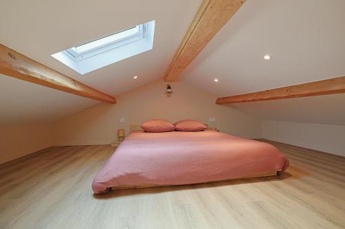 a bedroom with a large bed in a attic at LA BRISA Duplex chaleureux in Hyères