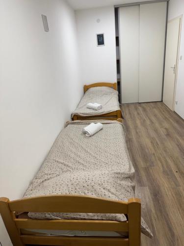 two beds in a room with wooden floors at Apartman Ðurđevak in Stara Pazova