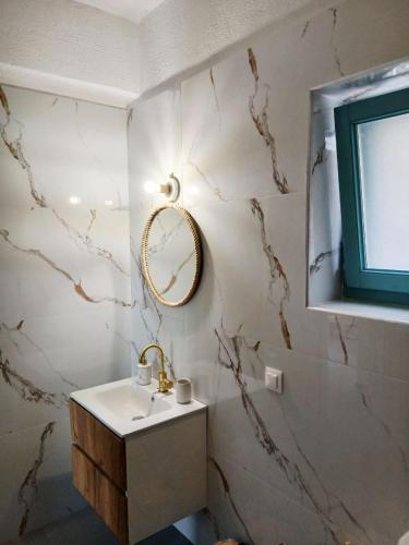 a bathroom with a sink and a mirror on the wall at Ελαιόλιθοι Μάνη Villas in Oitylo