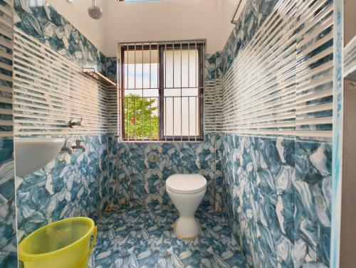 a bathroom with a toilet and a tub and a window at Premium AC Rooms at Taj Heritage Hotel and Restatrant in Jorhat