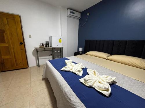 a bedroom with a bed with towels on it at Hostal Cabañas Don Jorge in Puerto Baquerizo Moreno