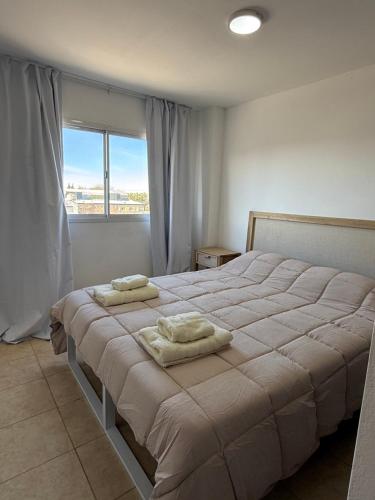 a bedroom with a large bed with two towels on it at Amelie 4 in General Roca