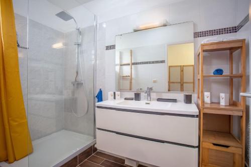 a white bathroom with a sink and a shower at DOUC 'IRMA Appt T3 à 5 mn à pied de la Plage de l'anse à L'âne in Les Trois-Îlets