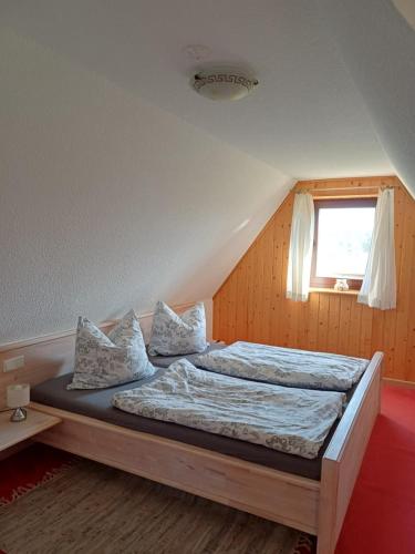 a bedroom with a bed with pillows and a window at Ferienhaus Rümdriewer in Pruchten