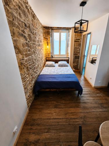 a bedroom with a bed and a brick wall at Cosy Appartement Hyper Centre-Ville in Quimper