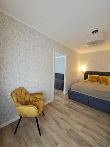 a bedroom with a bed and a chair in it at Comfort apartment in Rakvere in Rakvere