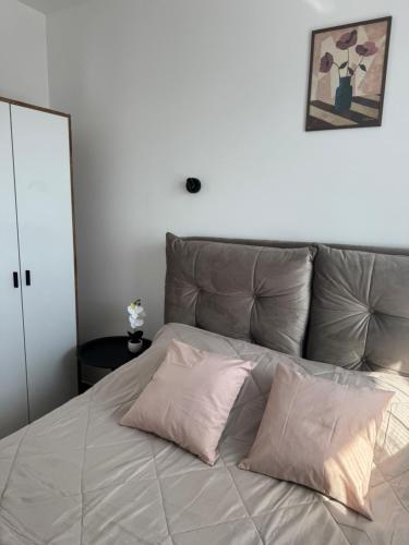 a bed with two pillows on top of it at Nest apartman 2 in Veliko Gradište