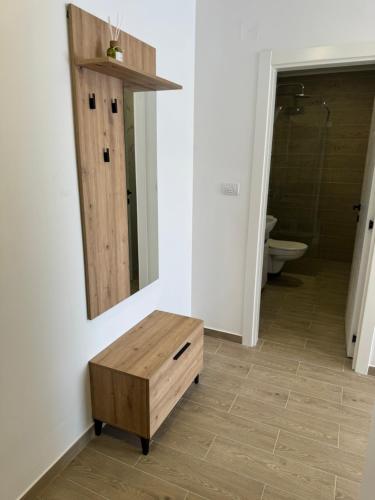 a bathroom with a table and a mirror on the wall at Nest apartman 2 in Veliko Gradište