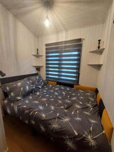 a bedroom with a bed in a room with a window at Domek w ogrodzie "Bzyczek" in Ostry Bór