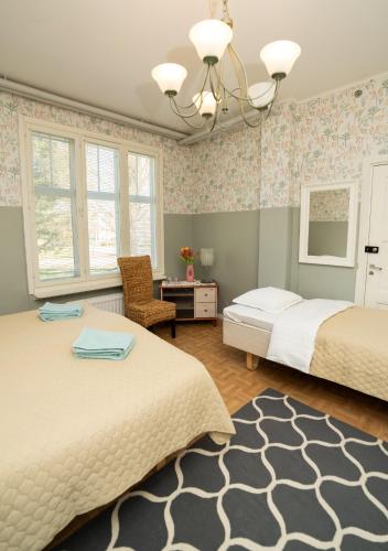 a bedroom with two beds and a desk at Majatalo Mäntän Kuusela in Mänttä