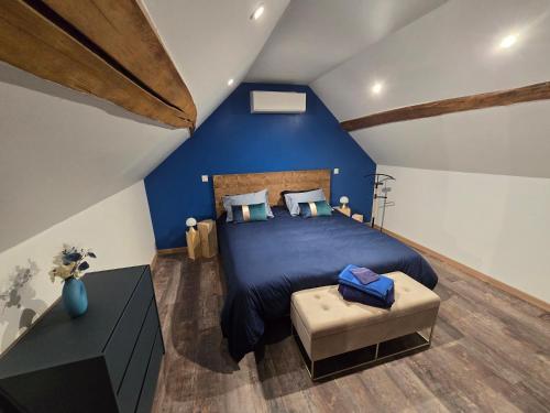a bedroom with a large bed and a blue wall at Sarments et Bulles in Ambonnay