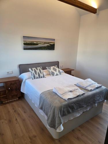 a bedroom with a bed with white sheets and pillows at Plaza España AT in Alcazar de San Juan