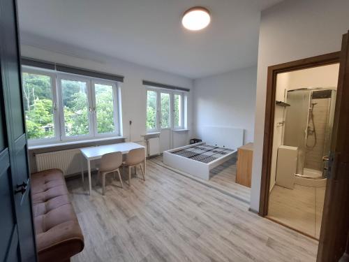 a kitchen and living room with a table and a refrigerator at Pokoje na lato Gdynia in Gdynia