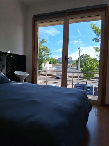 a bedroom with a bed and a large window at Jardim da Guarda Inglesa in Santa Clara