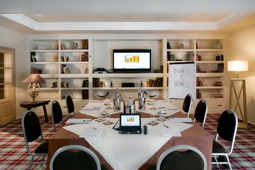 a room with a long table with chairs and a television at Val di Luce SPA Resort in Abetone