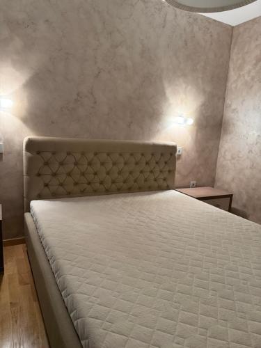 a bedroom with a bed with a white mattress at Swimming pool apartment in Budva