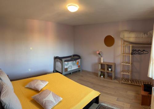 a bedroom with a yellow bed and a shelf at séjour en Alsace in Ingersheim