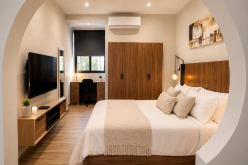 a bedroom with a large bed and a television at Sliema Arch Suites Modern Boutique Apartment in St. Julianʼs