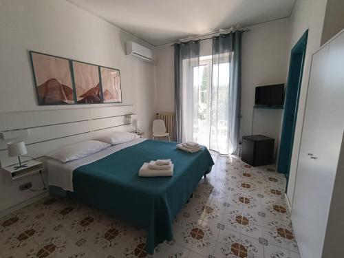 a bedroom with a bed with two towels on it at Villa Rosa Rooms in Ischia Town