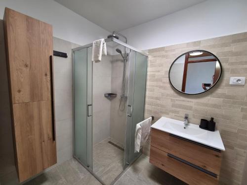 a bathroom with a shower and a sink and a mirror at Sunset Zaglav Apartment in Martinšćica