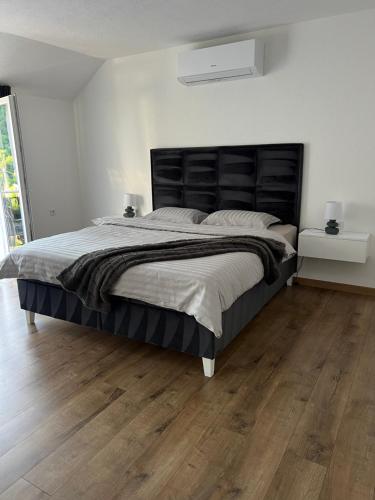 a bedroom with a large bed and a wooden floor at Apartman Rawda in Jajce