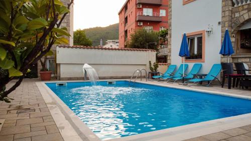 a swimming pool with a fountain in a building at Villa Iper Krystallos in Budva