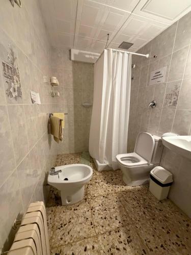 a bathroom with a toilet and a bidet and a sink at Miramar Viladecans in Viladecáns