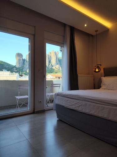 a hotel room with a bed and a large window at Meteora Gold and Glass in Kalabaka