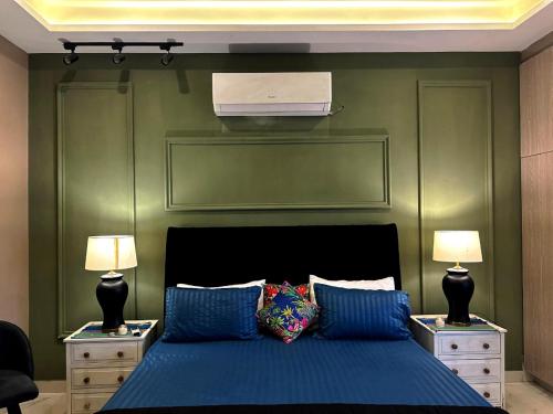 a bedroom with a bed and two night stands with lamps at River Hill in Rawalpindi