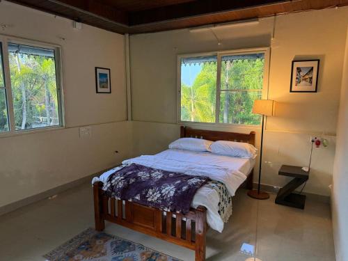 a bedroom with a bed in a room with windows at The Beach House in Cochin