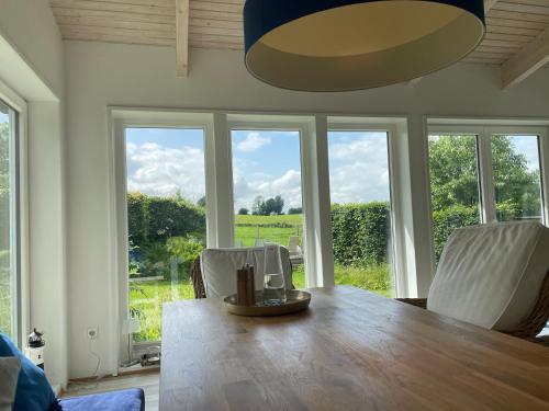 a dining room with a table and chairs and windows at Schleihaus Lorenz mit Feldblick in Boren