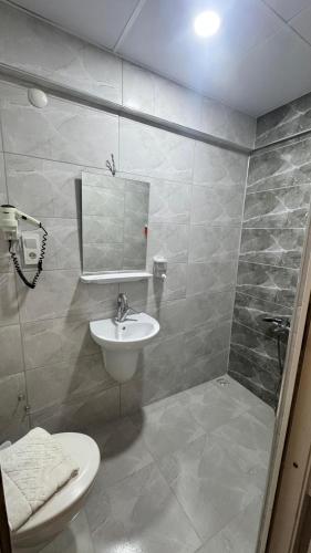 a bathroom with a sink and a toilet and a shower at Pera City Otel in Samsun