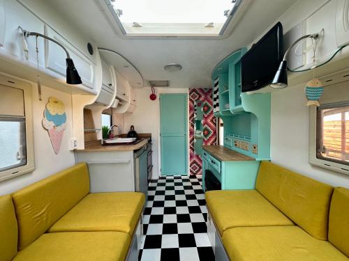 a train room with yellow seats and a checkered floor at Domki i przyczepy Kemping Sunday Camp in Władysławowo